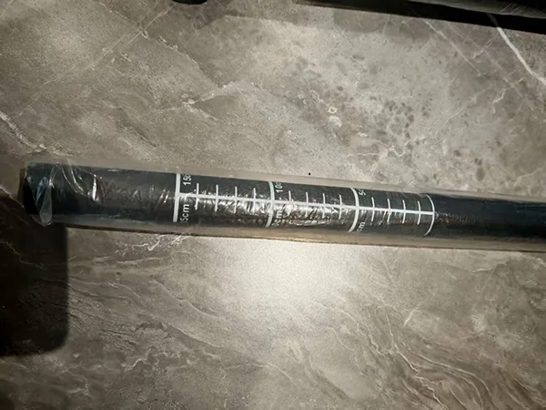 White graduation marks on a dark paddle shaft under protective wrapping