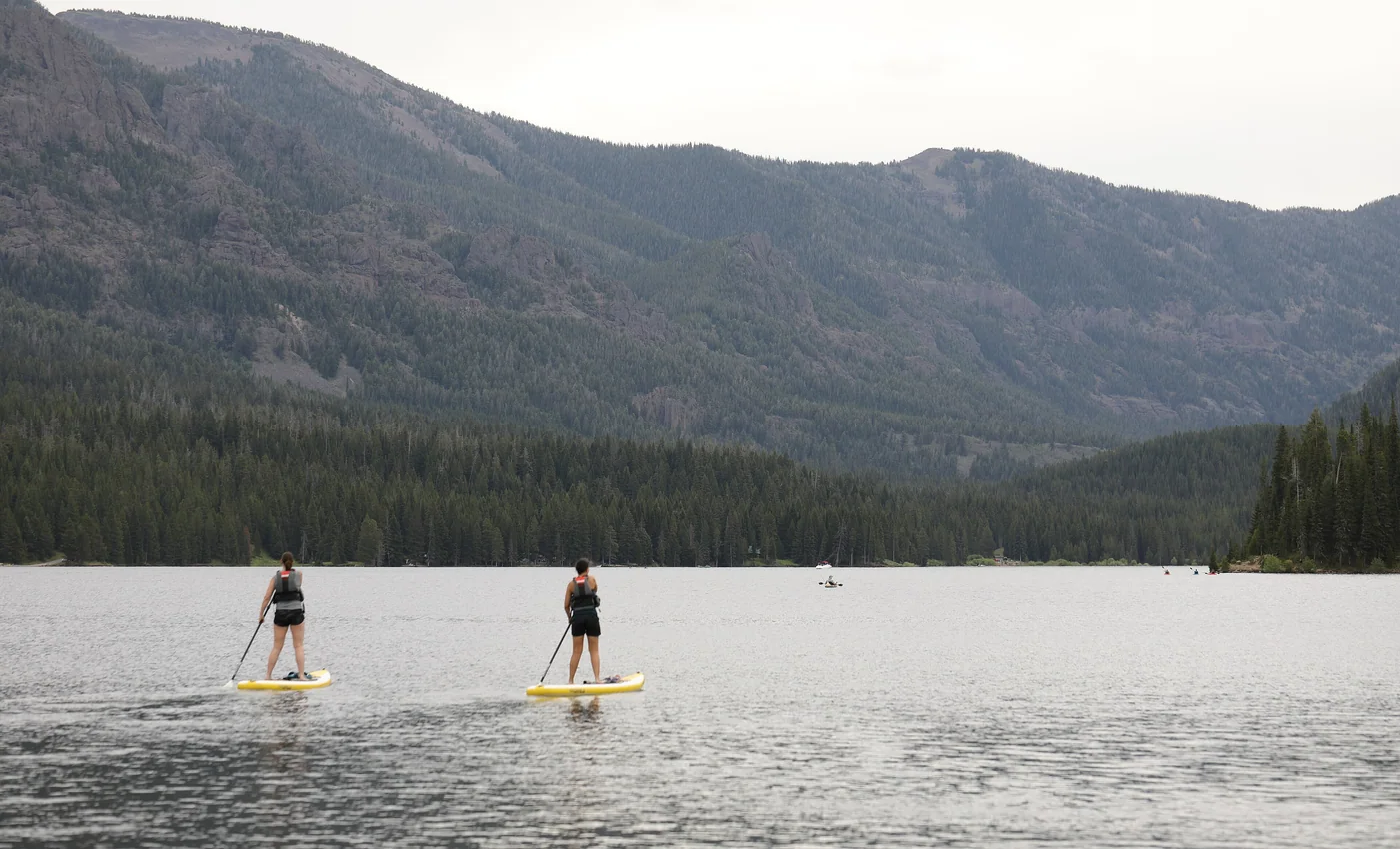Two stand up paddlers using paddles on Hyalite Reservoir