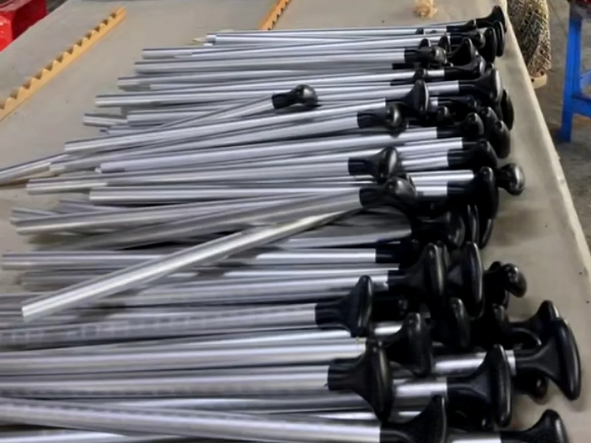 Assembled aluminum paddle shafts grouped on a production worktable