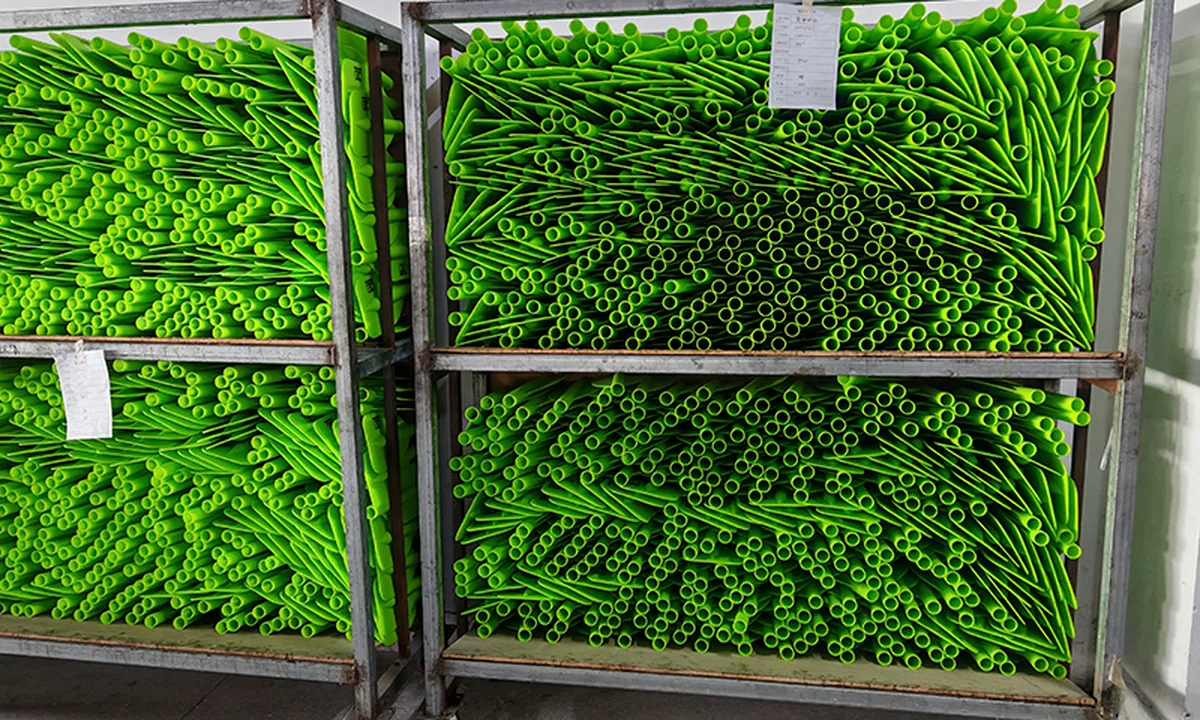 Green paddle shaft components grouped on metal production racks
